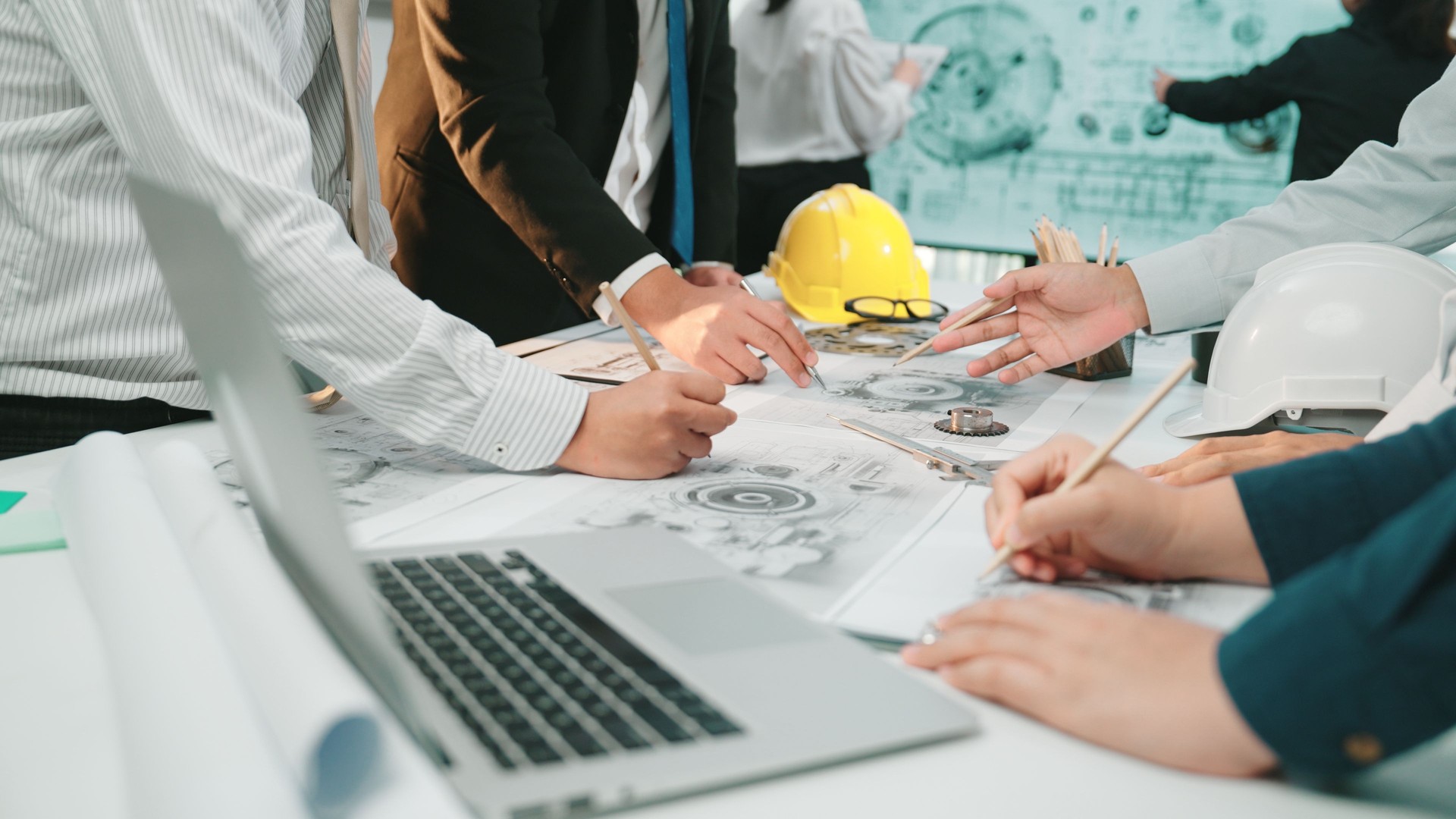 Collaborative Teamwork in Office Setting with Engineers and Architects Discussing Project Plans and Drafts on Table Surrounded by Construction Tools and Devices SACTR